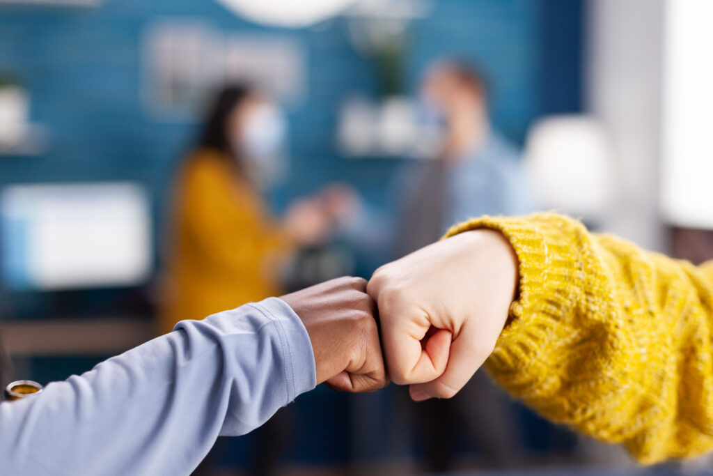 close up of african woman and friend doing fist bump