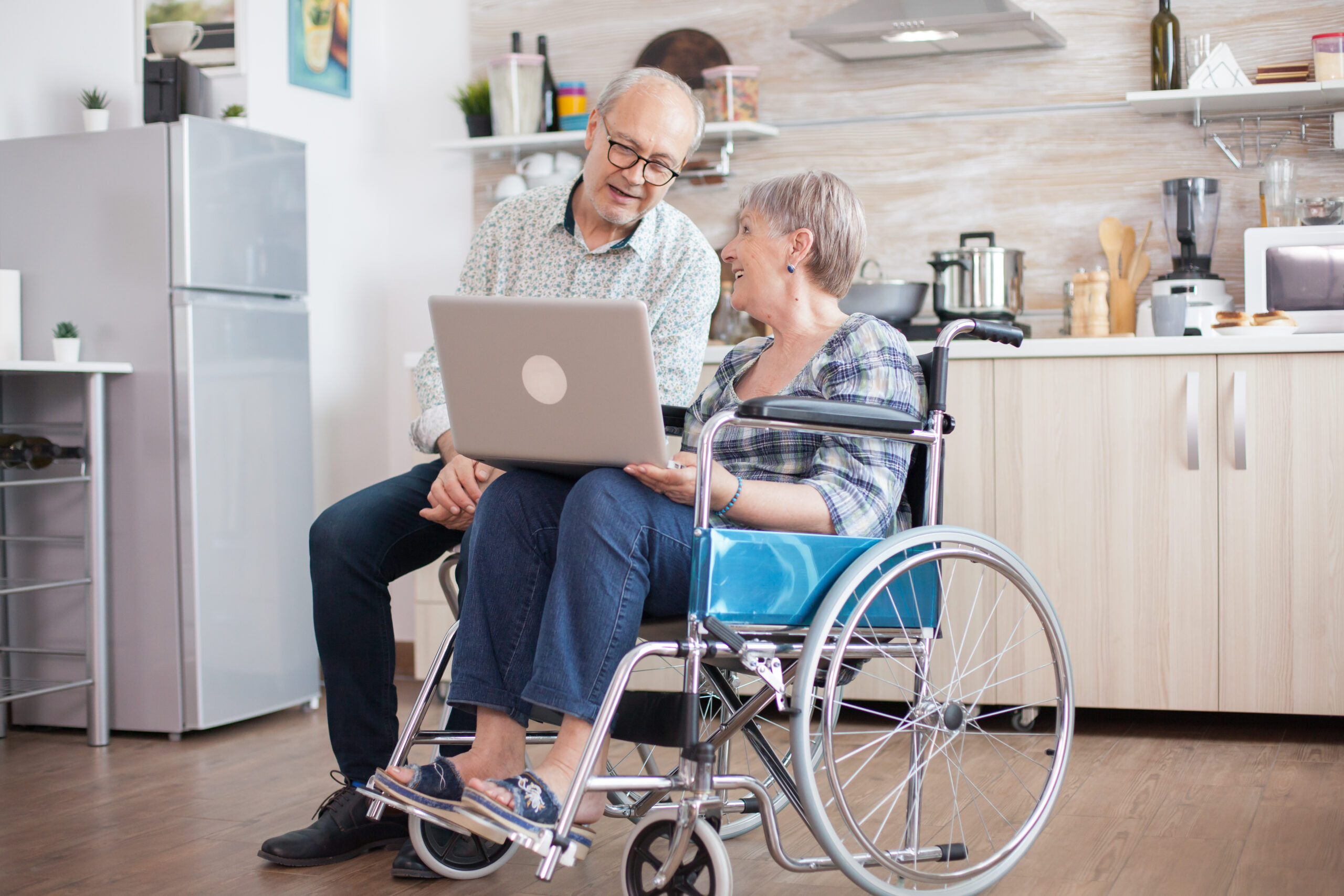 Disabled Senior Woman Wheelchair Her Husband Having Video Conference Tablet Pc Kitchen Paralyzed Old Woman Her Husband Having Online Conference Scaled