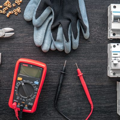 different electrical tools on wooden background, flat lay.