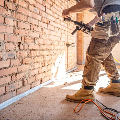 the builder works with a drill in working form.